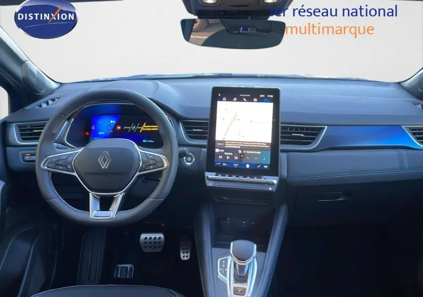Intérieur avant du Renault Symbioz bleu Iron Metal, tableau de bord moderne avec écran tactile vertical et volant multifonction.