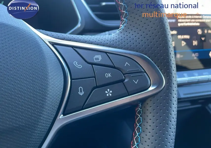Gros plan sur les commandes du volant en cuir noir perforé avec surpiqûres tricolores du Renault Symbioz E-Tech Hybrid 2025.