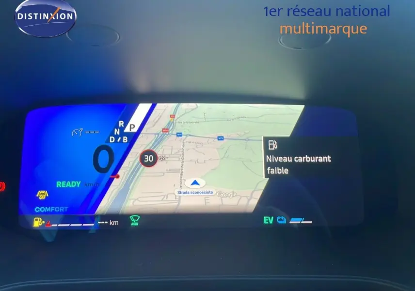 Tableau de bord numérique du Renault Symbioz bleu Iron Metal affichant navigation et alerte niveau carburant faible.