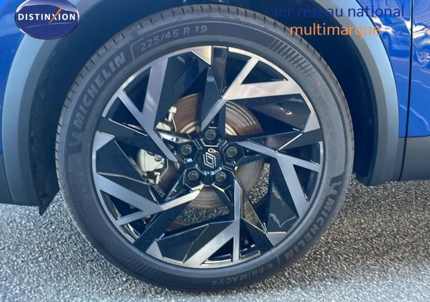 Gros plan sur la roue avant droite bleu iron metal de la Renault Symbioz E-Tech Full Hybrid 145 Esprit Alpine avec jante noire et argent.