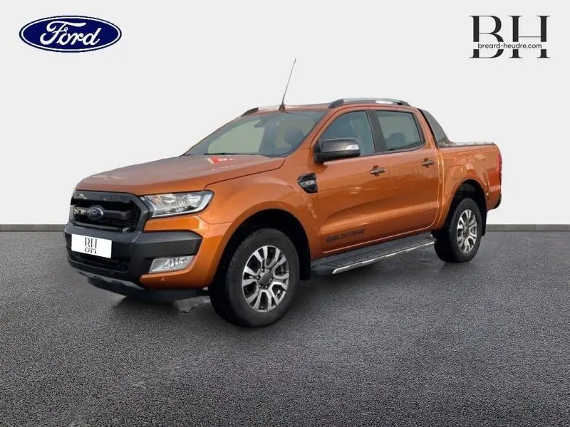Ford Ranger Wildtrak 2017 Pride Orange métallisée, vue 3/4 avant droit avec barres de toit et marchepieds.