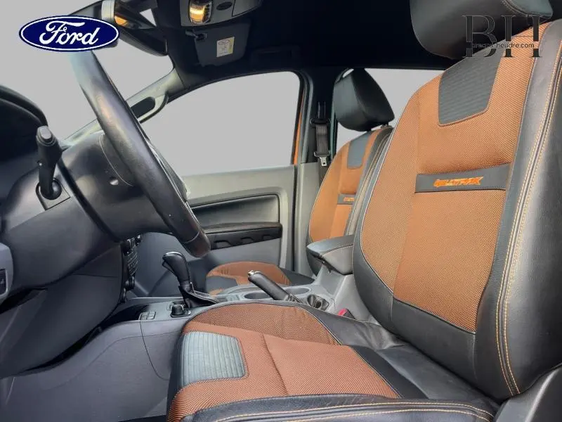 Vue intérieure côté conducteur du Ford Ranger Wildtrak 2017 avec sièges cuir orange et noir distinctifs.