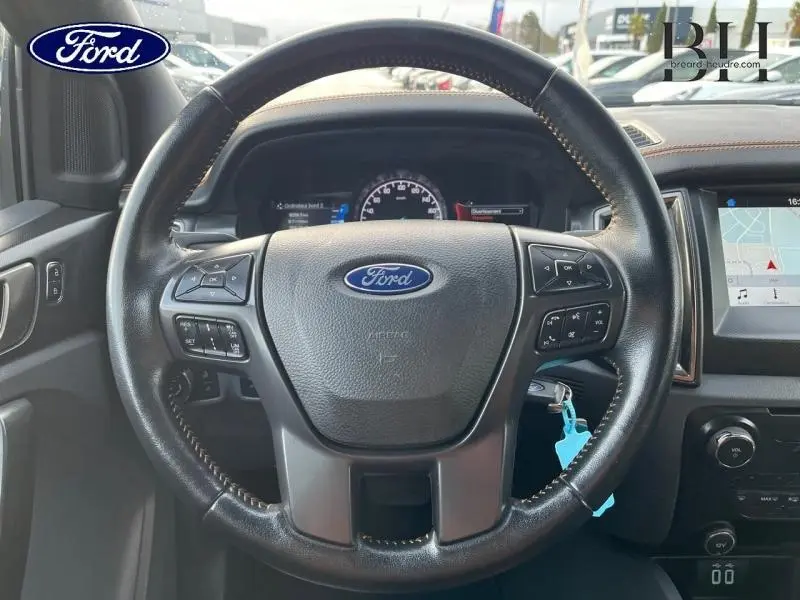 Vue intérieure centrée sur le volant cuir noir du Ford Ranger 2017 avec tableau de bord et écran tactile visibles.