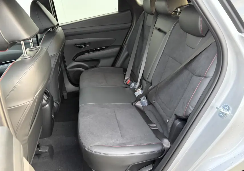 Vue intérieure côté droit des sièges arrière cuir/alcantara noirs avec surpiqûres rouges du Hyundai Tucson IV Shimmering Silver.