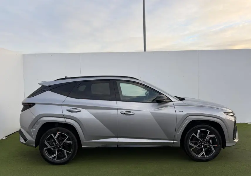 Hyundai Tucson 2025 hybride en Shimmering Silver Metal, vue profil côté gauche avec jantes alliage 19'' N Line.
