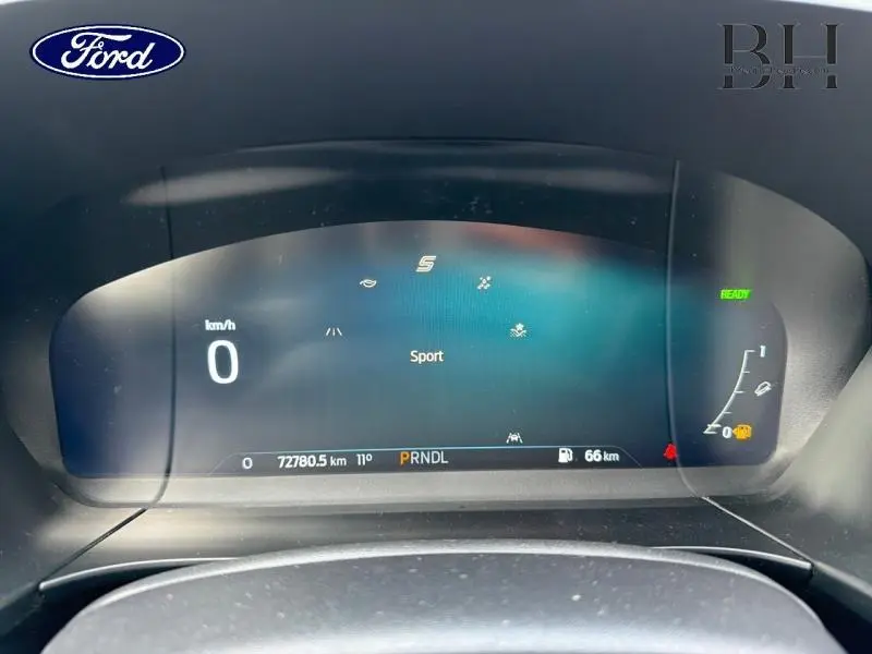 Vue rapprochée du tableau de bord numérique du Ford Kuga 2022, affichant le mode Sport et l'autonomie restante.