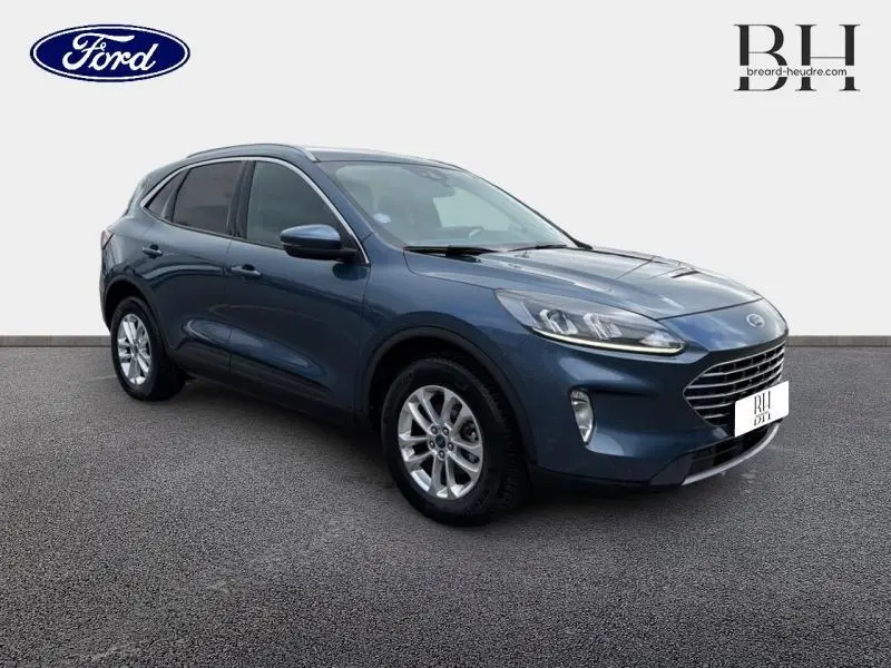 Vue 3/4 avant d'un Ford Kuga 2022 bleu azur métallisé avec vitres arrière surteintées et jantes alu.