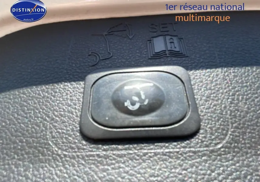 Gros plan sur le bouton de fermeture électrique du coffre du Ford Kuga blanc, intérieur noir texturé.