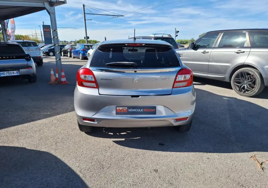 Vue arrière d'une Suzuki Baleno gris clair de 2017 avec vitres surteintées et jantes alliage 16 pouces.