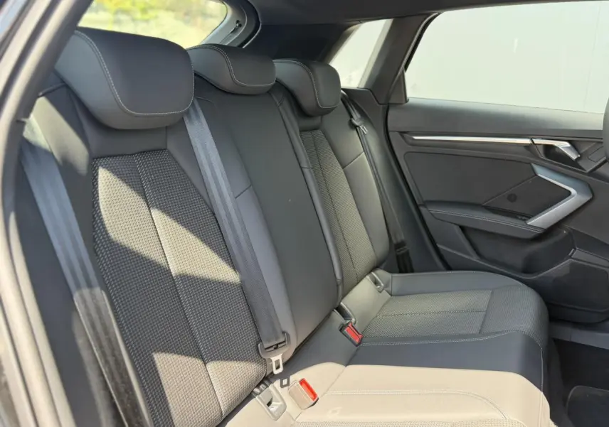 Vue latérale droite de la banquette arrière en tissu noir avec ceintures de sécurité sur Audi A3 Sportback 2025.