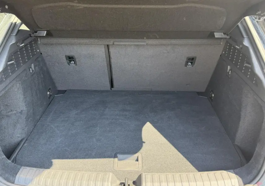Coffre ouvert vu de l'arrière d'une Audi A3 Sportback noir Mythe, espace de chargement propre et vide.