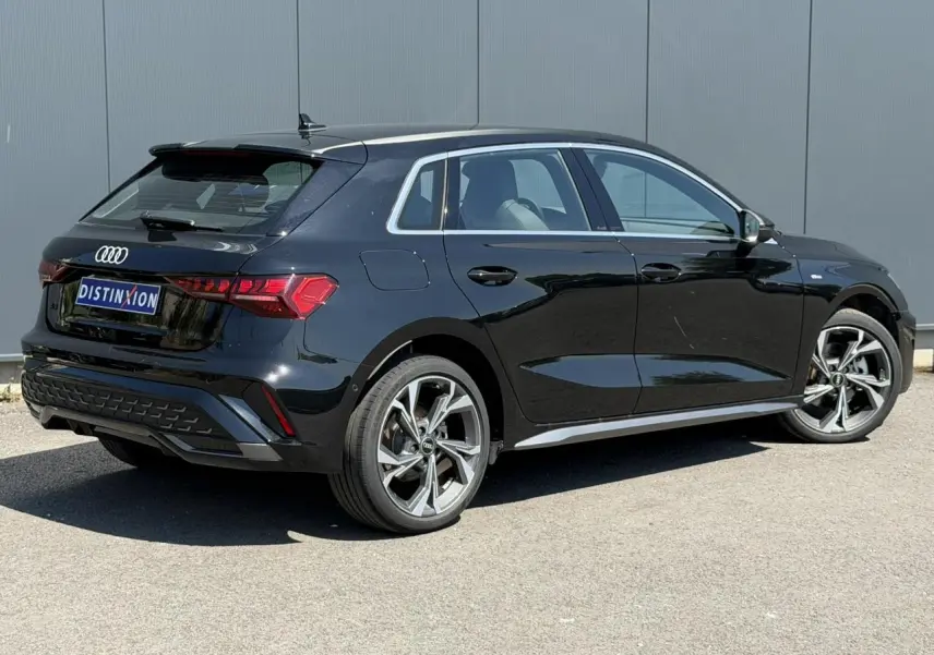 Audi A3 Sportback noir Mythe vue 3/4 arrière droit avec jantes alliage 5 branches en Y brillantes.