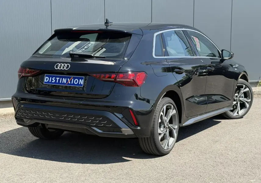 Audi A3 Sportback noir Mythe vue 3/4 arrière droit, avec jantes alliage 5 branches en Y et feux arrière LED distinctifs.