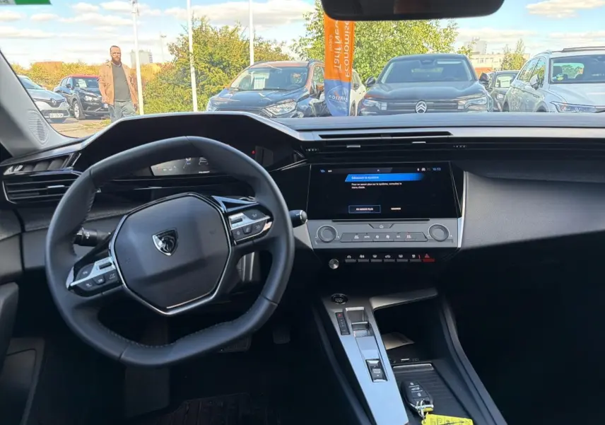 Vue intérieure avant du Peugeot 308 2025, tableau de bord moderne avec écran tactile et volant multifonction noir.