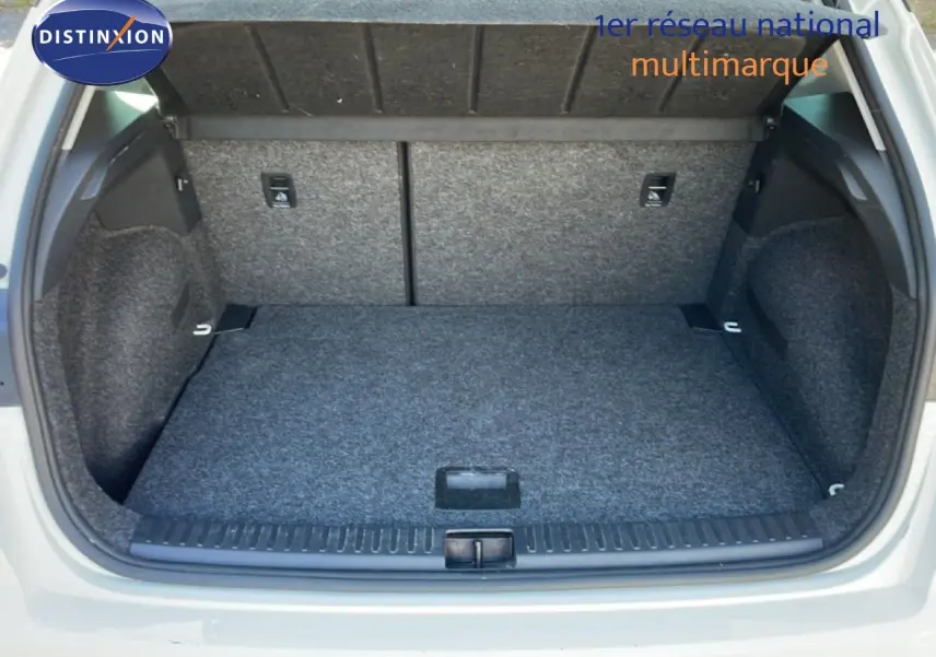 Coffre ouvert vu de l'arrière d'un SEAT Arona blanc métal avec toit noir, montrant un espace de chargement propre et spacieux.