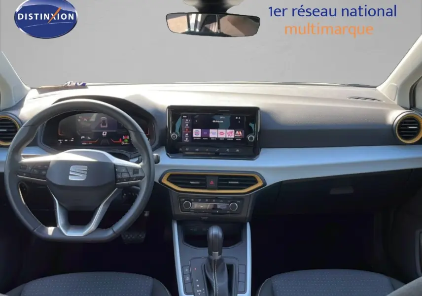 Vue intérieure avant du SEAT Arona blanc métal avec toit noir, tableau de bord moderne et volant multifonction.
