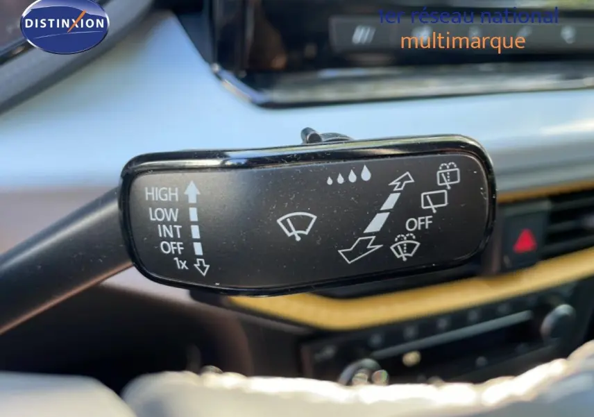 Gros plan sur la commande des essuie-glaces dans l’habitacle d’un SEAT Arona blanc métal avec toit noir.