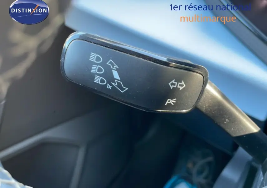 Gros plan sur la manette de clignotant du SEAT Arona 2025, intérieur gris noir, volant partiellement visible.