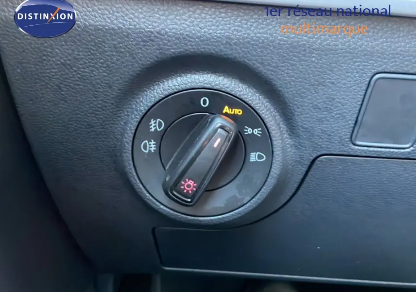 Gros plan sur la molette de réglage des phares dans l’habitacle du SEAT Arona blanc métal avec toit noir.