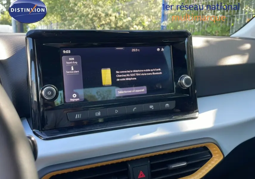 Vue rapprochée de l’écran tactile central du tableau de bord du SEAT Arona 2025 avec finition intérieure claire et détails jaunes.
