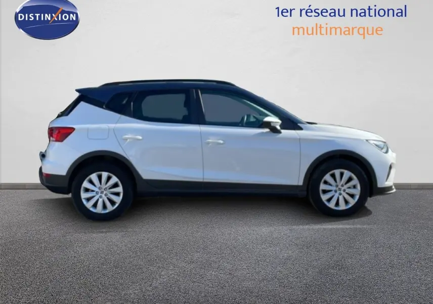 Vue latérale gauche d'un SEAT Arona blanc métal avec toit noir, roues alliage et vitres teintées.