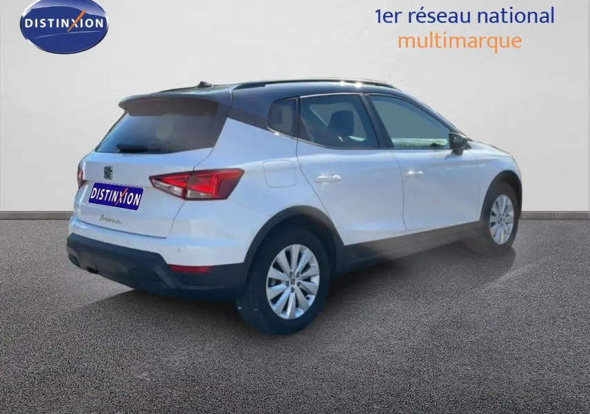 SEAT Arona blanc métal avec toit noir en 3/4 arrière droit, soulignant son design compact et moderne.