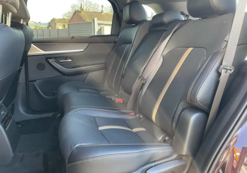 Vue latérale des sièges arrière en cuir noir avec surpiqûres contrastantes du Mazda CX-80 2024.