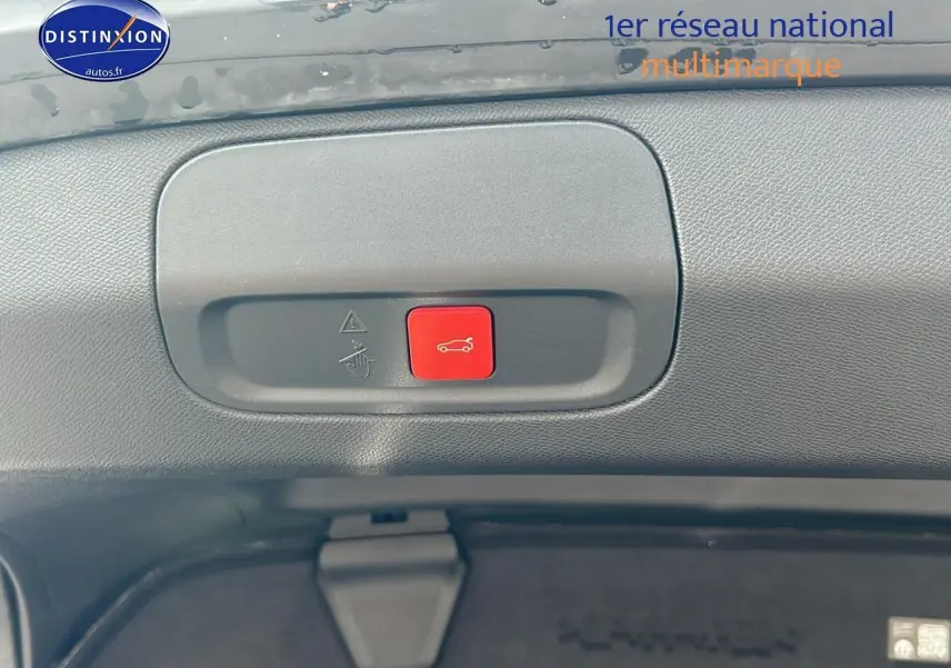 Gros plan sur le bouton rouge d'ouverture électrique du coffre du Peugeot 408 Hybrid 145 GT noir, vue intérieure arrière.