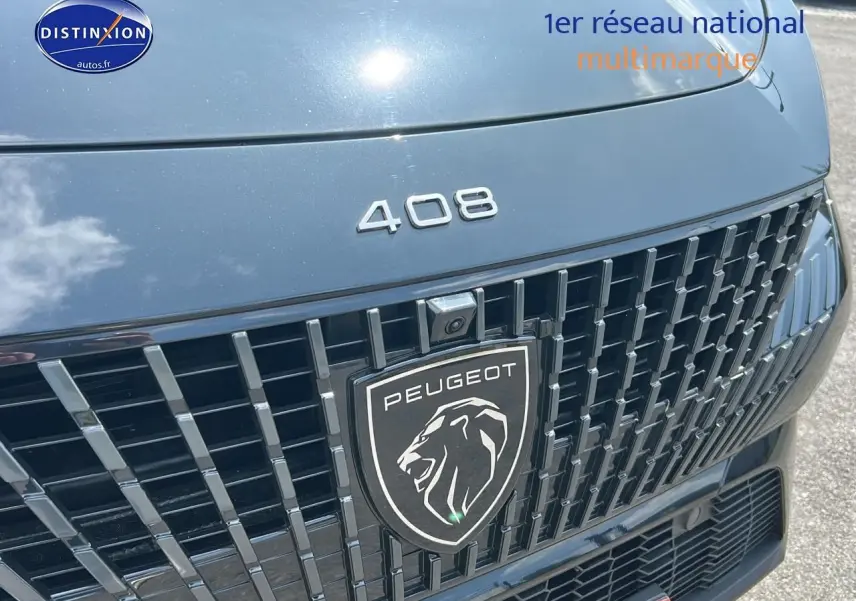 Gros plan sur la calandre noire brillante et le logo Peugeot du 408 Hybrid 145 GT e-dcs6 2024.