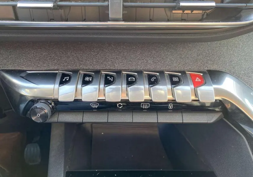 Gros plan sur la rangée de commandes chromées du tableau de bord du Peugeot 3008 gris foncé de 2019.