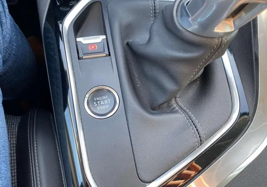Gros plan sur la console centrale du Peugeot 3008 gris foncé, montrant le levier de vitesse manuel et le bouton start/stop.