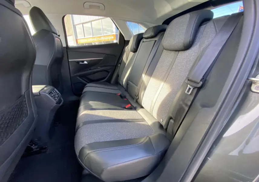 Vue intérieure arrière droite des sièges arrière en tissu et cuir du Peugeot 3008 gris foncé, avec ceinture de sécurité visible.
