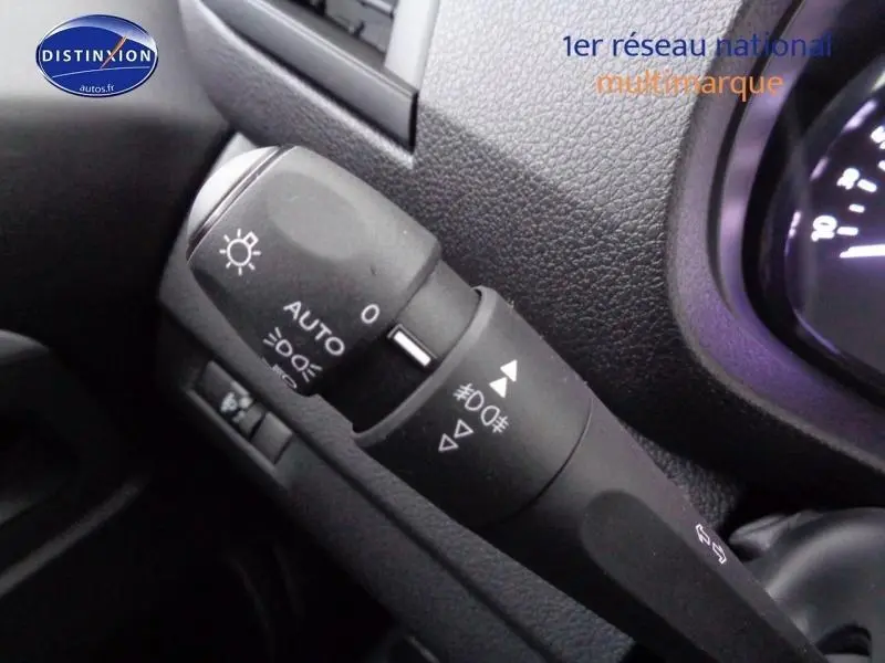 Gros plan sur la commande des phares du Peugeot Expert Fourgon gris acier, avec tableau de bord en arrière-plan.