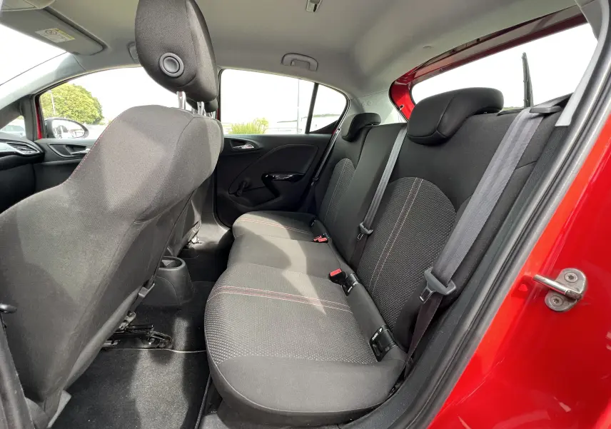 Vue intérieure côté droit sur la banquette arrière noire avec surpiqûres rouges de l'Opel Corsa rouge 5 portes 2018.