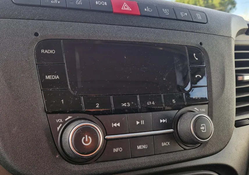 Gros plan sur la console centrale noire de l'IVECO Daily Fourgon 2023, montrant l'autoradio et les commandes multimédias.