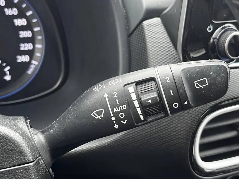 Gros plan sur la commande des essuie-glaces du Hyundai Kona bleu 2020, avec réglages visibles et tableau de bord partiel.