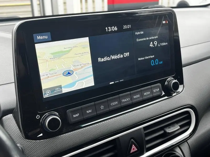 Écran tactile central du tableau de bord du Hyundai Kona bleu, affichant navigation et informations hybrides.