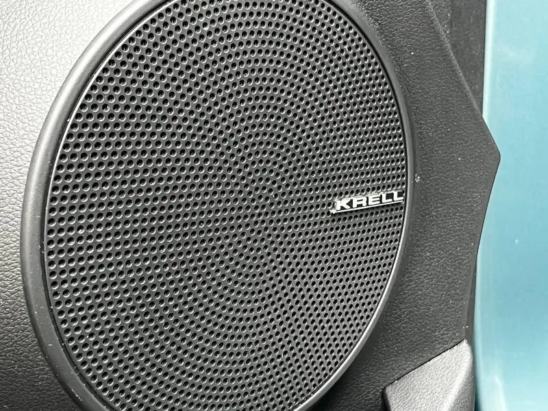 Gros plan sur le haut-parleur Krell noir intégré à la porte côté gauche d’un Hyundai Kona bleu.