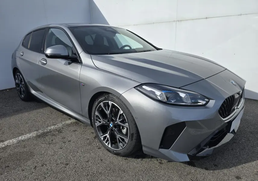 BMW Série 1 gris Skyscraper vue 3/4 avant droit avec calandre noire et jantes alliage 18 pouces M Sport.