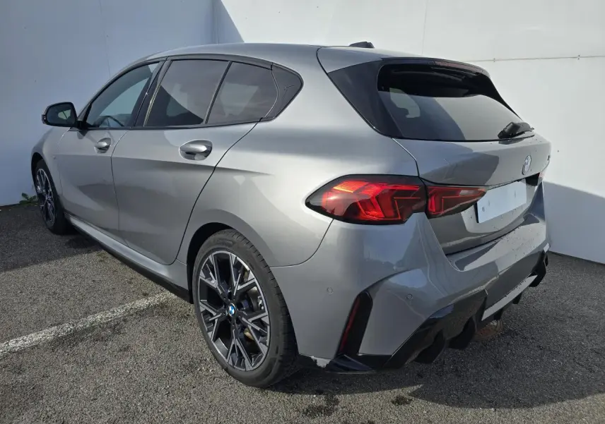 BMW Série 1 gris Skyscraper vue 3/4 arrière droit avec toit noir et jantes alliage 18 pouces M Sport.