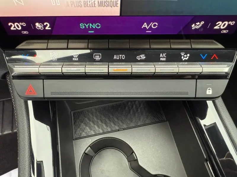 Vue rapprochée de la console centrale du Renault Austral 2025 rouge, montrant les commandes climatisation et rangement.