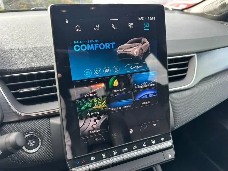 Écran tactile central du Renault Captur 2026 en mode confort, intérieur gris avec détails noirs, vue de face côté passager.