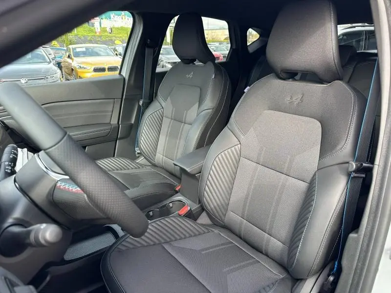 Vue intérieure côté conducteur du Renault Captur 2026, sièges gris avec logo Alpine brodé et coutures contrastées.