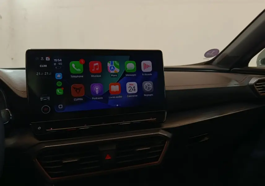 Vue intérieure du tableau de bord du CUPRA Formentor 1.4 e-HYBRID 2024 avec écran tactile central affichant Apple CarPlay.