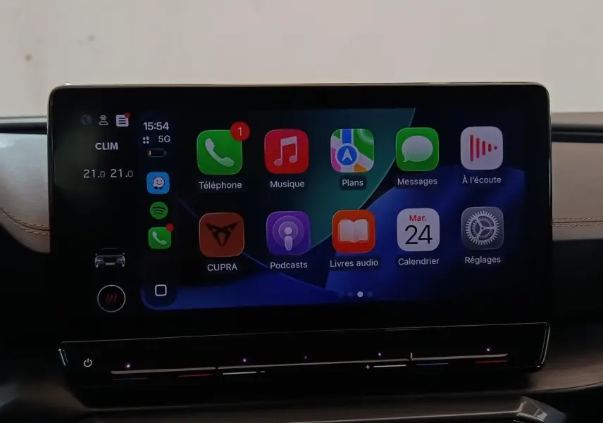 Écran tactile central de la CUPRA Formentor 2024 affichant Apple CarPlay avec fond noir et détails lumineux.