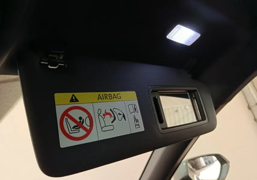 Détail du pare-soleil côté conducteur avec miroir intégré et étiquette airbag dans un CUPRA Formentor noir.