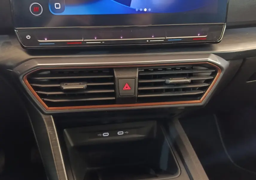 Détail du tableau de bord noir de la CUPRA Formentor 2024, avec écran tactile et aérateurs encadrés de cuivre.