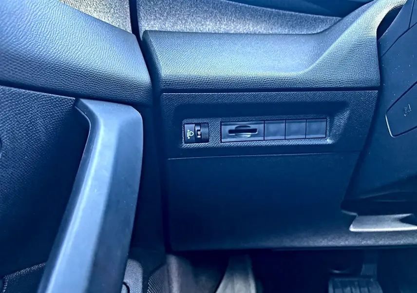 Détail du tableau de bord côté gauche noir du Peugeot 308 1.5 BlueHDi 130 Allure 2025 avec commande éclairage.