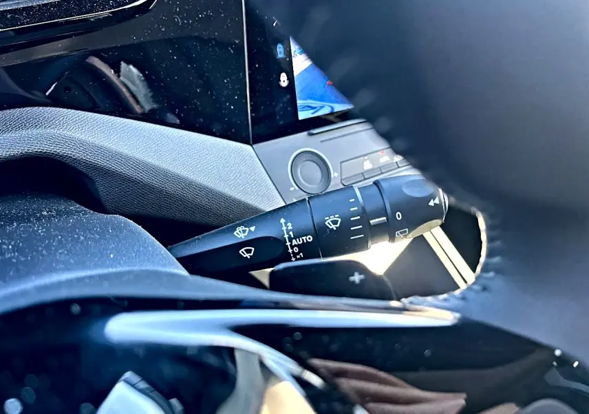 Gros plan sur la commande d’essuie-glace côté droit du volant dans l’habitacle noir de la Peugeot 308 2025.