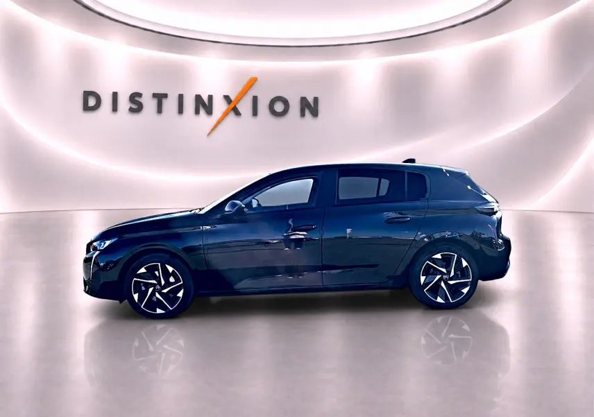 Peugeot 308 noire vue de profil côté gauche, avec jantes alu distinctives dans un studio lumineux.